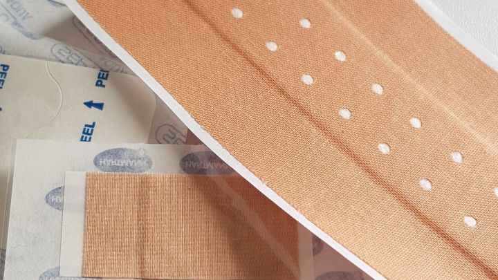 Ein Pflaster liegt auf einer Oberfl&auml;che, bereit zur Anwendung bei einer schmerzenden Blase am Fu&szlig;.