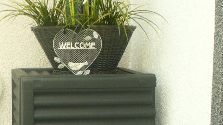 Eine platzsparende Auflagenbox steht an der Wand, dekoriert mit einem Blumenk&uuml;bel, ideal f&uuml;r Terrasse oder Balkon.