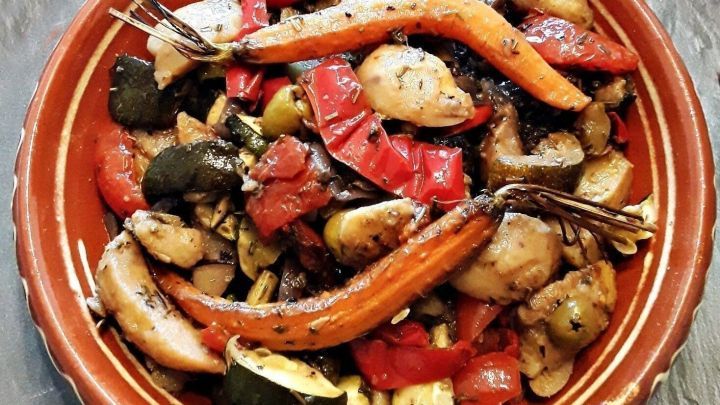 Ein bunter mediterraner Ofengem&uuml;se-Kartoffelsalat liegt auf einem rustikalen Teller und wird appetitlich pr&auml;sentiert.