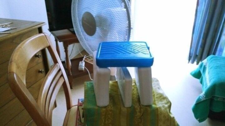 Eine provisorische Klimaanlage besteht aus einem Ventilator, der kalte Luft durch eine K&uuml;hlfl&auml;che leitet, um den Raum abzuk&uuml;hlen.