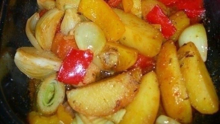 Eine bunte Mischung aus gebratenen Erd&auml;pfeln und Lauch in einer Pfanne, dampfend und appetitlich angerichtet.