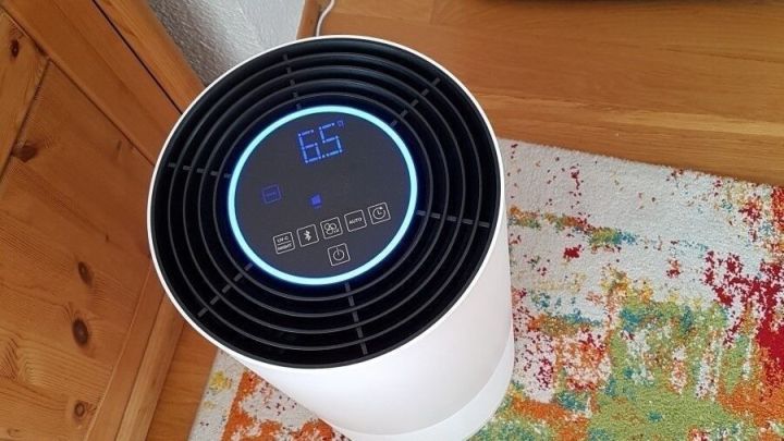Ein Luftreiniger steht auf einem bunten Teppich und zeigt die Temperatur an, um Allergien durch Pollen zu lindern.