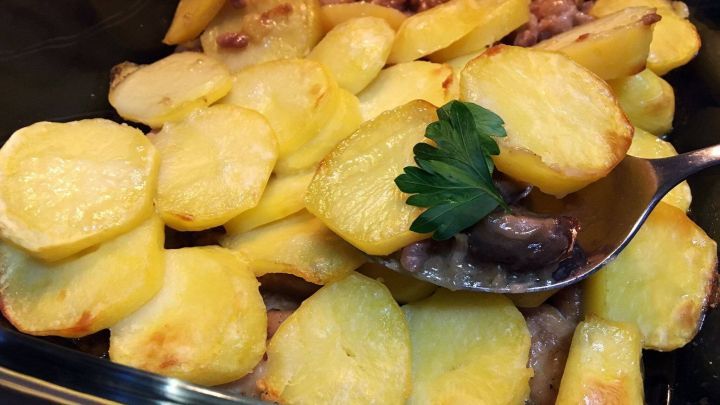 Ein cremiger H&auml;hnchen-Kartoffel-Auflauf mit goldbraun gebackenen Kartoffeln und einer Portion frisch gehackter Petersilie.