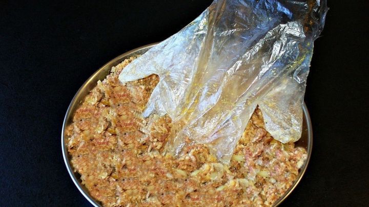 &Uuml;bergro&szlig;e Plastikhandschuhe liegen &uuml;ber einer Sch&uuml;ssel mit einer Mischung, ideal f&uuml;r hygienisches Arbeiten in der K&uuml;che.