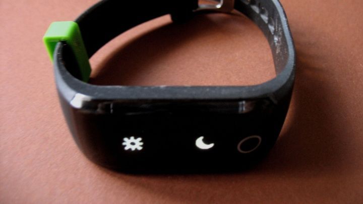 Eine schwarze Fitnessuhr liegt auf einem braunen Untergrund, bereit, die Bewegung und Fitness des Nutzers zu verfolgen.