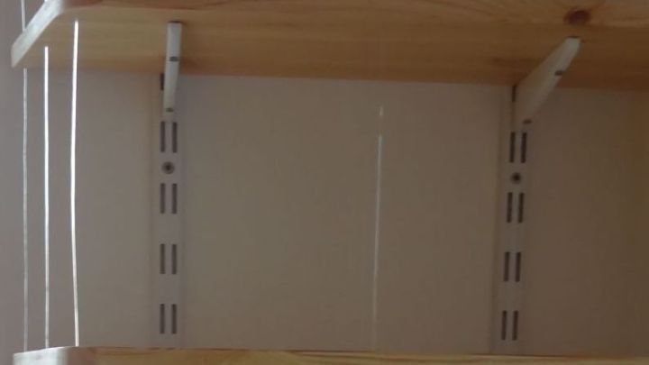 Ein offenes B&uuml;cherregal mit diskreten Seitenw&auml;nden bietet Platz f&uuml;r B&uuml;cher und Dekoration, umgeben von neutralen W&auml;nden.