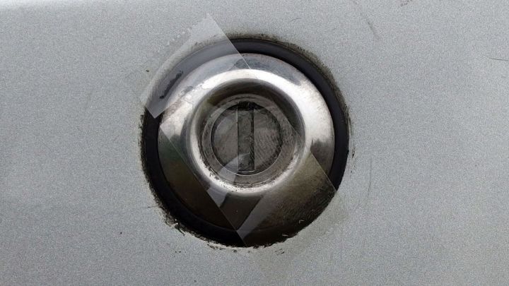 Ein Autot&uuml;rschloss ist im Fokus, umgeben von einer grauen Karosserie; der Schl&uuml;sselbereich zeigt Spuren von Frostschutzma&szlig;nahmen.