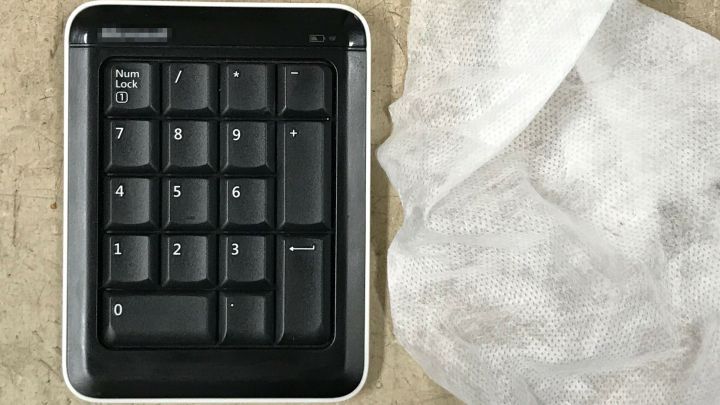 Ein schwarzes Ziffernblatt wird von einem feuchten Tuch gereinigt, um klebrige Oberfl&auml;chen zu s&auml;ubern.