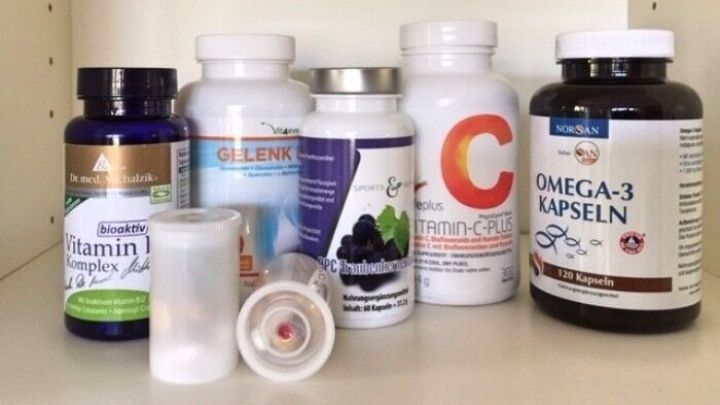 Auf einem Regal stehen verschiedene Flaschen mit Vitaminen, darunter kleine Portionen und ein Beh&auml;lter f&uuml;r unterwegs.