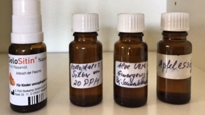 Ein Spray und drei kleinere Braunglasfl&auml;schchen stehen auf einem Regal. Sie enthalten Medikamente f&uuml;r eine Notfallausr&uuml;stung.