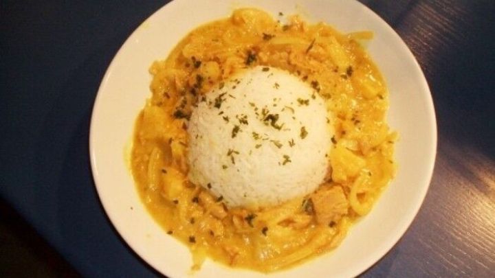 Ein Teller mit Jasminreis liegt in der Mitte, umgeben von einer cremigen Zwiebel-Thunfisch-Sauce, die appetitlich aussieht.