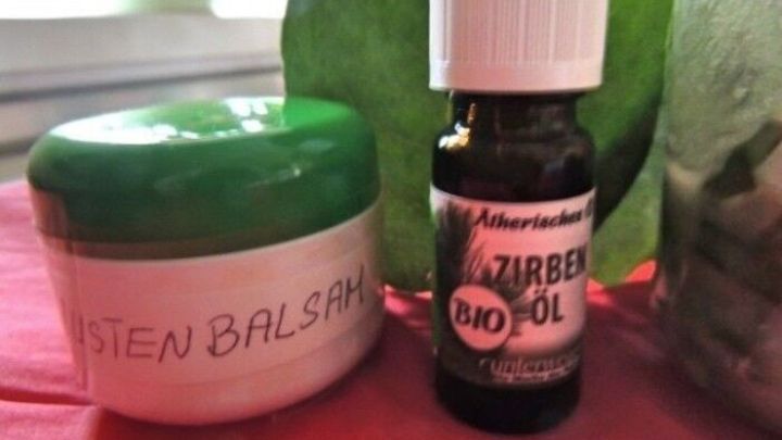 Ein Glasbeh&auml;lter mit gr&uuml;nem Deckel enth&auml;lt Hustenbalsam, daneben steht eine Eukalyptus&ouml;l-Flasche auf einem Tisch.