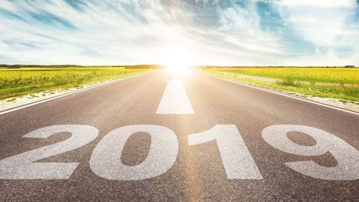 Eine geradlinige Stra&szlig;e mit der Zahl &bdquo;2019&ldquo; darauf f&uuml;hrt in die Helligkeit einer erleuchteten Zukunft in einer l&auml;ndlichen Umgebung.