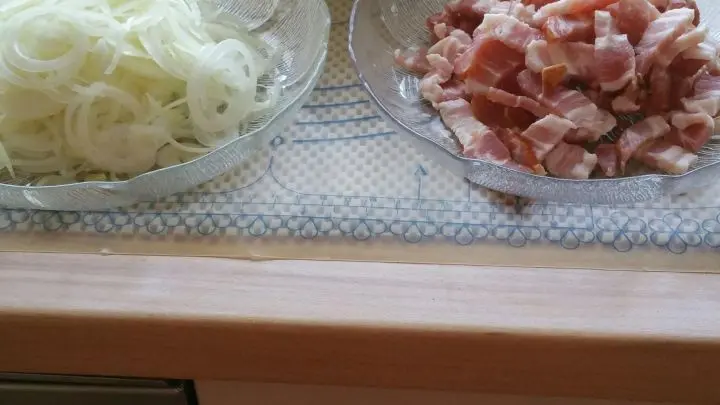 In der Zwischenzeit Speck und und Zwiebeln schneiden, Schmand mit Creme fraiche verrühren mit Salz und Pfeffer abschmecken.