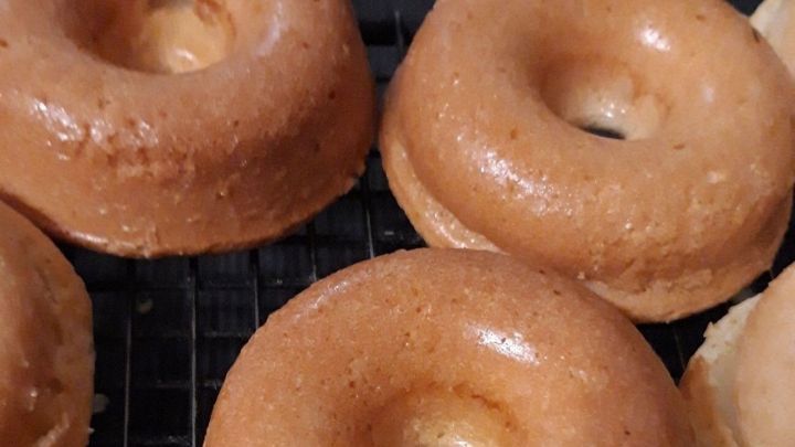 Bananen-Apfel-Donuts liegen frisch auf einem Gitter und warten darauf, genossen zu werden.