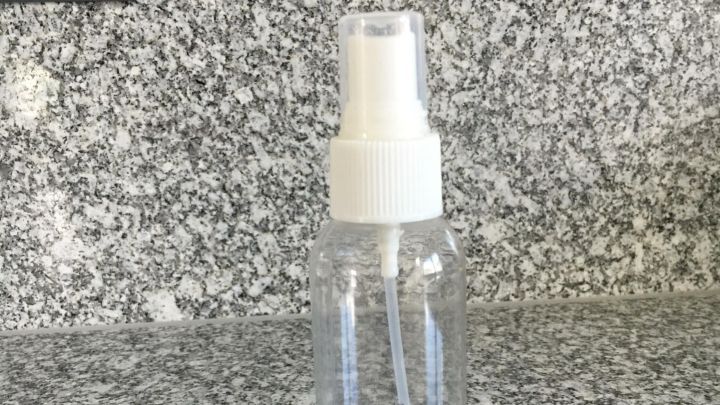 Eine Spr&uuml;hflasche mit der Beschriftung "Brille" steht auf einer grauen Arbeitsplatte, bereit zum Reinigen von Brillen.