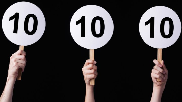 H&auml;nde halten Bewertungstafeln mit der Zahl 10. Der Hintergrund ist schwarz, was die Zahlen hervorhebt und betont.