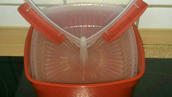 Ein roter Dampfgarer f&uuml;r die Mikrowelle steht auf dem K&uuml;chentisch, bereit, Gem&uuml;se schonend zu garen.