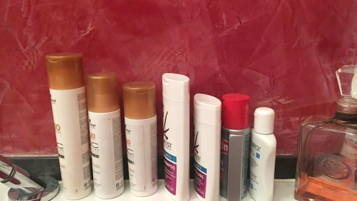 Haarpflegeprodukte stehen auf einem Waschbecken. Sie werden verwendet, um mehr Volumen ins Haar zu bekommen.