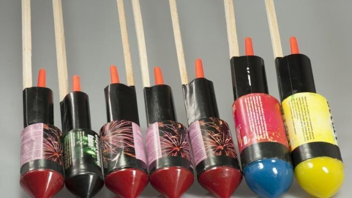 Silvesterraketen stehen vertikal auf einem grauen Untergrund, perfekt zum Blumen anbinden, mit bunten Verpackungen.