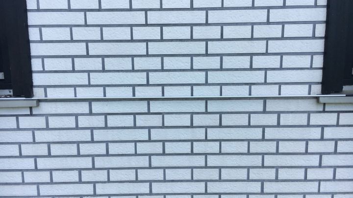 Eine strukturierte Ziegelwand ist im Hintergrund sichtbar, w&auml;hrend das automatische Bew&auml;sserungssystem fast unsichtbar in den Fugen agiert.