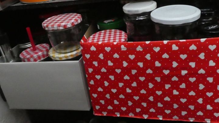 Vorratsgl&auml;ser werden in einer roten Box mit Herzen aufbewahrt und sind ordentlich in einem Regal angeordnet.