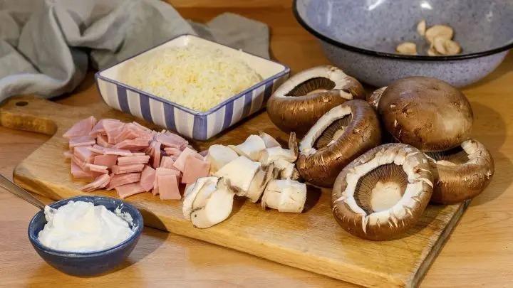 Die Champignons gut waschen und vom Stiel befreien. Nun schneide den Schinken ein wenig klein.