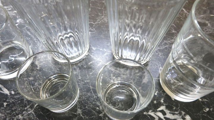 Sechs Gl&auml;ser stehen auf einem dunklen, marmorierten Tisch, bereit f&uuml;r den Transport w&auml;hrend des Umzugs.