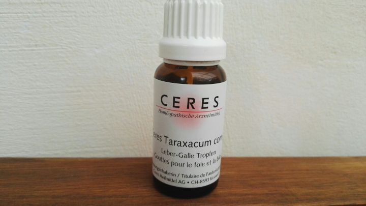 Ein Glasfl&auml;schchen mit klarer Fl&uuml;ssigkeit steht auf einer Holzoberfl&auml;che. Es enth&auml;lt ein Produkt zur nachhaltigen Linderung von Akne.