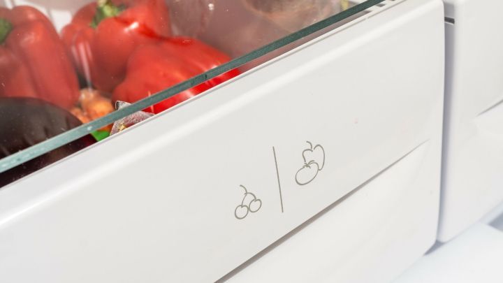 Eine Gem&uuml;seschublade mit zwei symbolischen Einstellungen f&uuml;r Feuchtigkeit, gef&uuml;llt mit frischen Paprika.