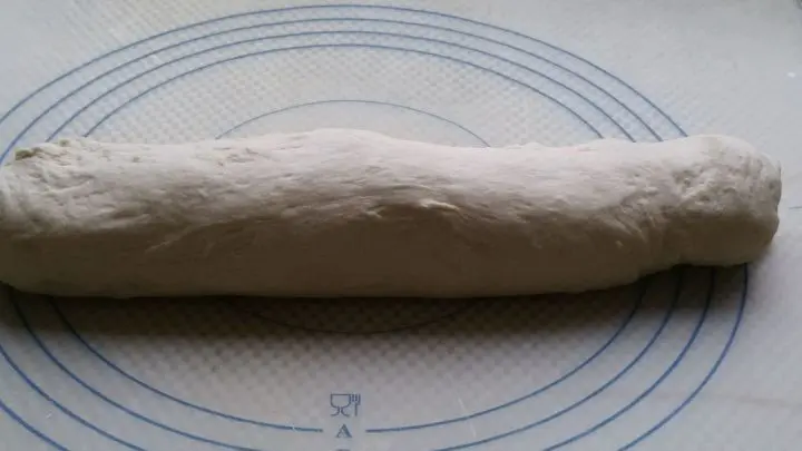 Einen Strang aus dem Teig rollen. Davon acht Teiglinge abstechen und mit der hohlen Hand kreisrund rollen. 