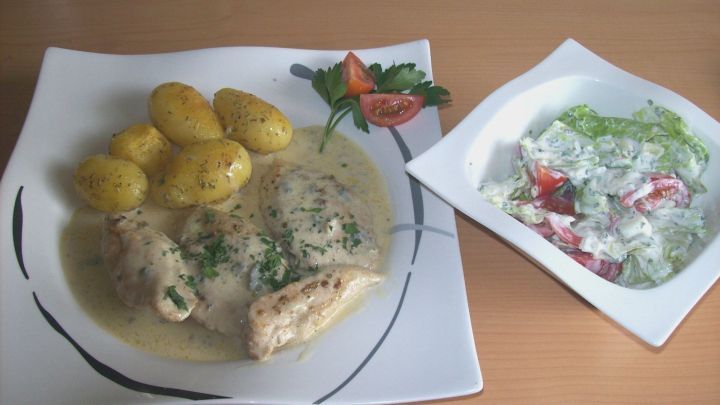 H&auml;hnchen-Schnitzel in Gorgonzola-So&szlig;e wird zusammen mit Kartoffeln und einem gemischten Salat serviert.