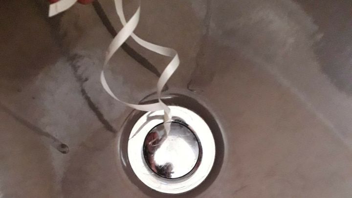 Ein Badewannenst&ouml;psel liegt zentral in der Wanne, mit einem Zugband, um ihn zu bet&auml;tigen, um Wasser zu halten.