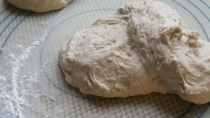 Auf einer bemehlten Backunterlage Teig von Hand kurz durchkneten. Wenn er noch zu weich ist, solltet ihr Mehl dazu kneten.