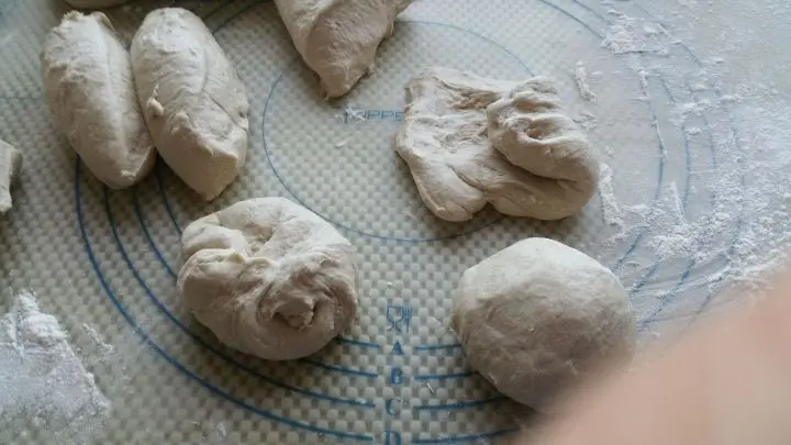 Teiglinge ein wenig ziehen und falten, bis sie fast rund sind. Umdrehen und zu einer Kugel schleifen.
