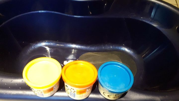 Bunte Farben in Beh&auml;ltern stehen in einer Badewanne, bereit f&uuml;r kreativen Malspa&szlig; f&uuml;r Kinder, ohne Flecken in der Wohnung.