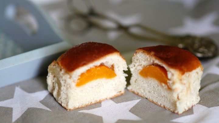 Leckere Hefeteigst&uuml;cke mit Obstf&uuml;llung liegen auf einem sternenf&ouml;rmigen Tischtuch und laden zum Probieren ein.