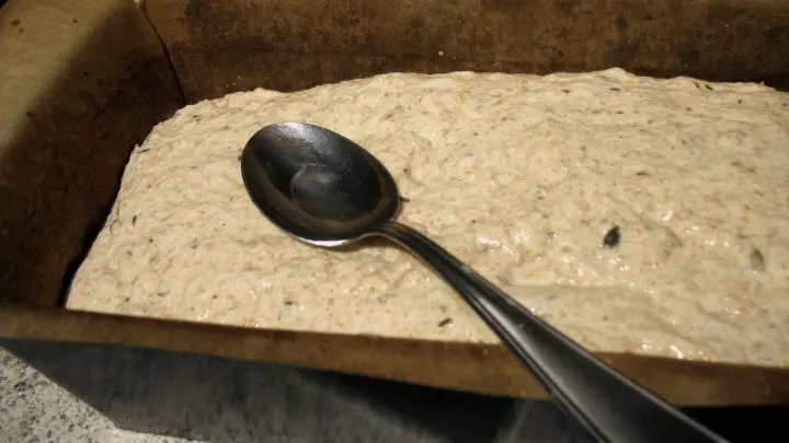 Mit einem feuchten Löffelrücken wird der Teig gleichmäßig in der Form verteilt und dabei wird gleichzeitig die Oberfläche gut mit Wasser befeuchtet.