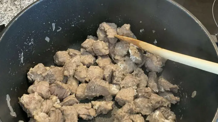 Im gleichen Topf Erdnuss&ouml;l erhitzen, die restlichen Schalotten anbrutzeln und das Fleisch rundherum scharf anbraten. 
