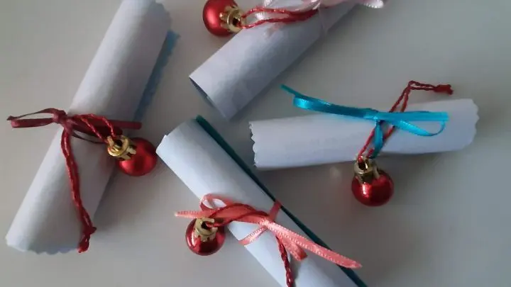 Zwecks Eint&uuml;tens habe ich jedes Gedicht vorsichtig gerollt, mit einer Schleife versehen, unter die eine kleine Tannenbaumkugel am Band geschoben wird.