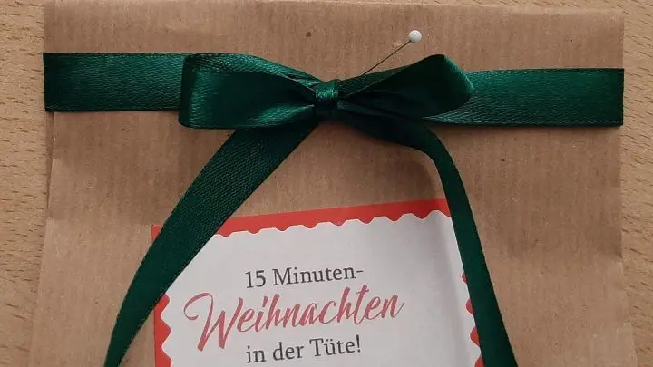 Nun kann man die Schleife ganz entspannt binden, die Enden pfeilf&ouml;rmig einschneiden und dann erst die Stecknadel wieder entfernen.