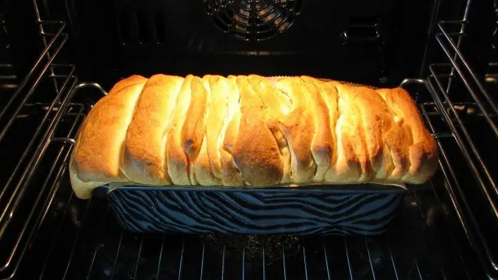 Das vorbereitete Zupfbrot 1&frac12; Stunde vor der Kaffeezeit aus dem K&uuml;hlschrank nehmen, in den Ofen stellen und diesen auf ca. 30 &deg;C einstellen. Nach 30 Minuten auf 180 &deg;C hochstellen und etwa 40-45 Minuten backen, bis er goldbraun und durchgebacken ist.