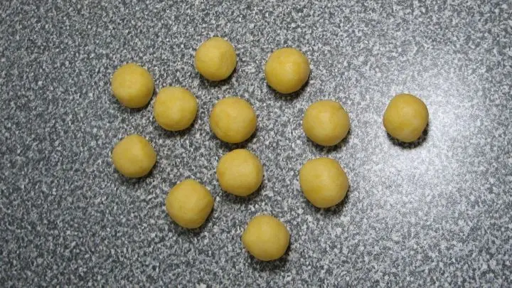 Teig in Portionen schneiden (ergibt 12 Stück) und kugelig formen (Größe zwischen Marzipankartoffel und Tischtennisball).