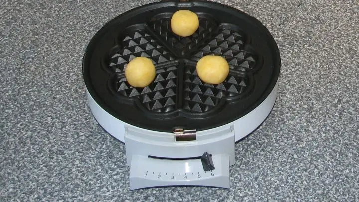 Waffeleisen vorheizen (ich besitze eins mit Thermostat von 1 bis 6 und habe Stufe 3 genommen). Maximal 3 Teigbällchen auf der Backfläche verteilen, Eisen schließen und kräftig drücken.