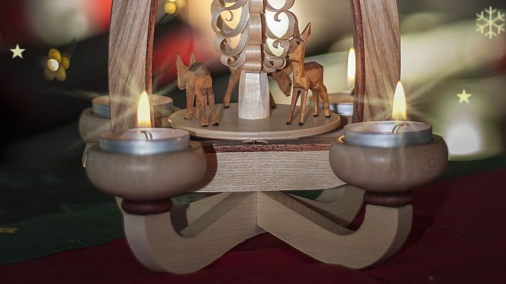 Eine Teelichtpyramide leuchtet sanft und dreht sich, w&auml;hrend sie in einer festlichen Umgebung dekoriert ist.