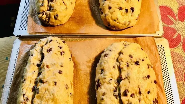 Zwei Backbleche mit L&ouml;chern (geht aber auch auf normalen Blechen) mit Backpapier belegen, zu Stollen einschlagen/formen, noch einmal kurz gehen lassen und ca. 1,5 Stunden bei 180 Grad Unter/Oberhitze abbacken.