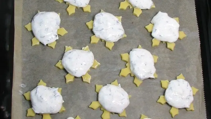 Von dem Baiser mit 2 Teel&ouml;ffeln Tupfen in die Mitte der Teigpl&auml;tzchen setzen. Im auf 190 &deg;C vorgeheizten Ofen bei Ober-/Unterhitze auf der mittleren Schiene 14-18 Minuten backen.