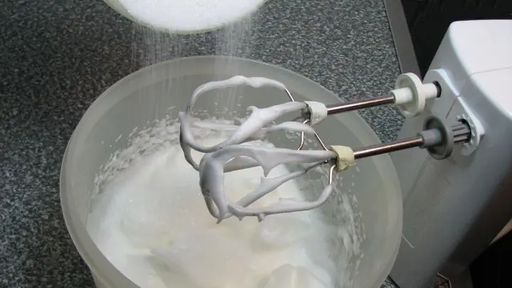 Die Eiwei&szlig; mit einer Prise Salz cremig steif schlagen. W&auml;hrend des Schlagens den Zucker nach und nach einrieseln lassen.