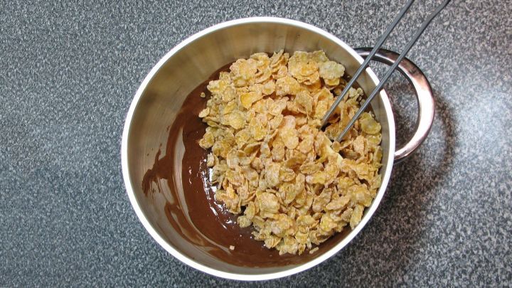 Cornflakes und Gew&uuml;rze zugeben und mit einem Teigschaber vorsichtig unterheben, es soll m&ouml;glichst nichts zerbr&ouml;seln &ndash; es dauert einen Moment bis kein einziges Cornflake mehr &ldquo;nackig&ldquo; ist.