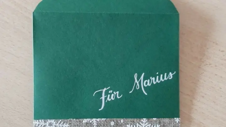 Die Kartenh&uuml;lle ist am unterem Rand mit einem wei&szlig; bedruckten Band beklebt, das mit doppelseitig klebenden Stylefix fixiert wurde.
